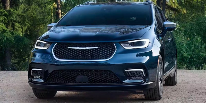 A dark blue minivan photographed from a low front angle