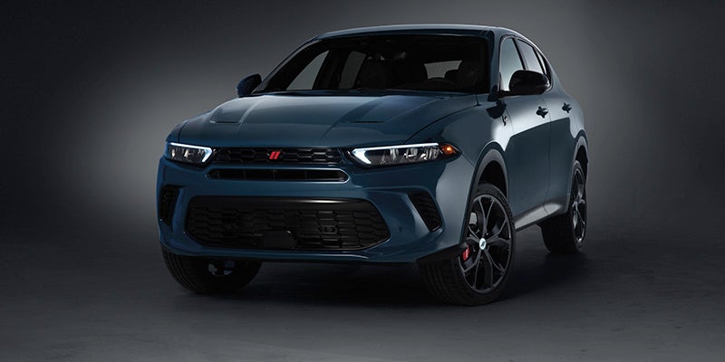 Front view of a dark blue Dodge Hornet crossover SUV with bright headlights