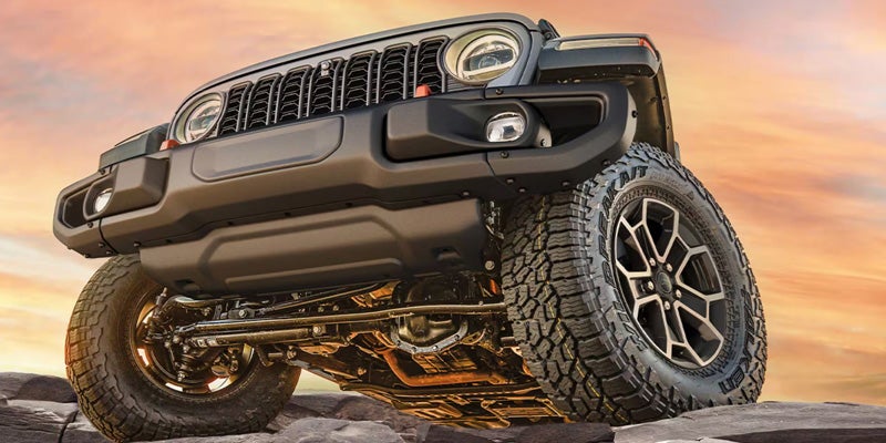 Close-up view of Jeep front bumper, grille, and off-road tire design