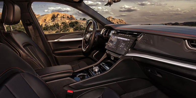 Premium Jeep SUV interior with digital display, dashboard, and center console